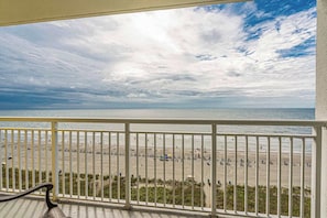 A beach view from a balcony with a railing, sandy beach, and ocean. - Ocean Front Views! Camelot Resort 1011 (Myrtle Beach)