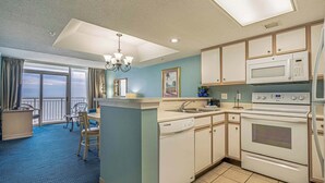 A kitchen with a microwave, oven, and sink.