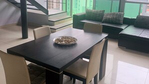 A modern living room with a dining table, chairs, a sofa, and a staircase. - modern Loft in city centre with amazing views - in the Financial District -  (Panamá)