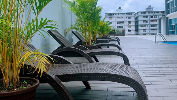 Outdoor seating with potted plants, a tiled floor, and modern buildings in the background. - modern Loft in city centre with amazing views - in the Financial District -  (Panamá)