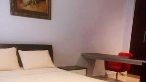 A hotel room with a large bed, a desk, and a red chair. - modern Loft in city centre with amazing views - in the Financial District -  (Panamá)