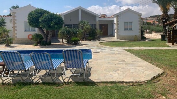 A two-story house with a swimming pool and lounge chairs. - Villa Amorosa in Neo Chorio (Neo Chorio)