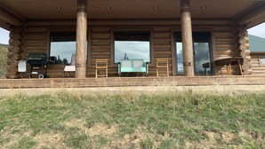 A log cabin with a covered porch, large windows, and a grill. - Western Slope Mountain Retreat. Privacy, solitude, incredible views (New Castle)