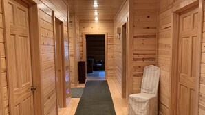 A wooden hallway with a green carpet, wooden doors, and a chair. - Western Slope Mountain Retreat. Privacy, solitude, incredible views (New Castle)