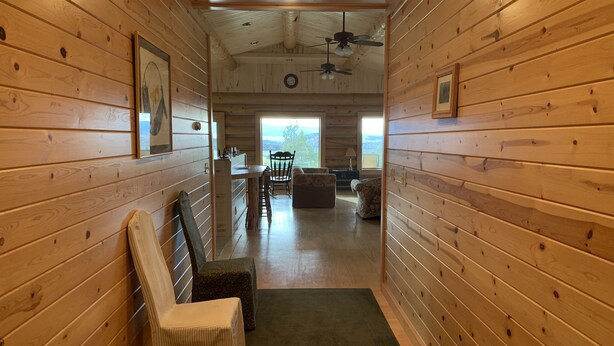 A wooden cabin interior with a dining area, a sofa, and a chair. - Western Slope Mountain Retreat. Privacy, solitude, incredible views (New Castle)