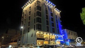 Ein mehrstöckiges Hotel mit beleuchteter Beschilderung und einem markanten Eingang.