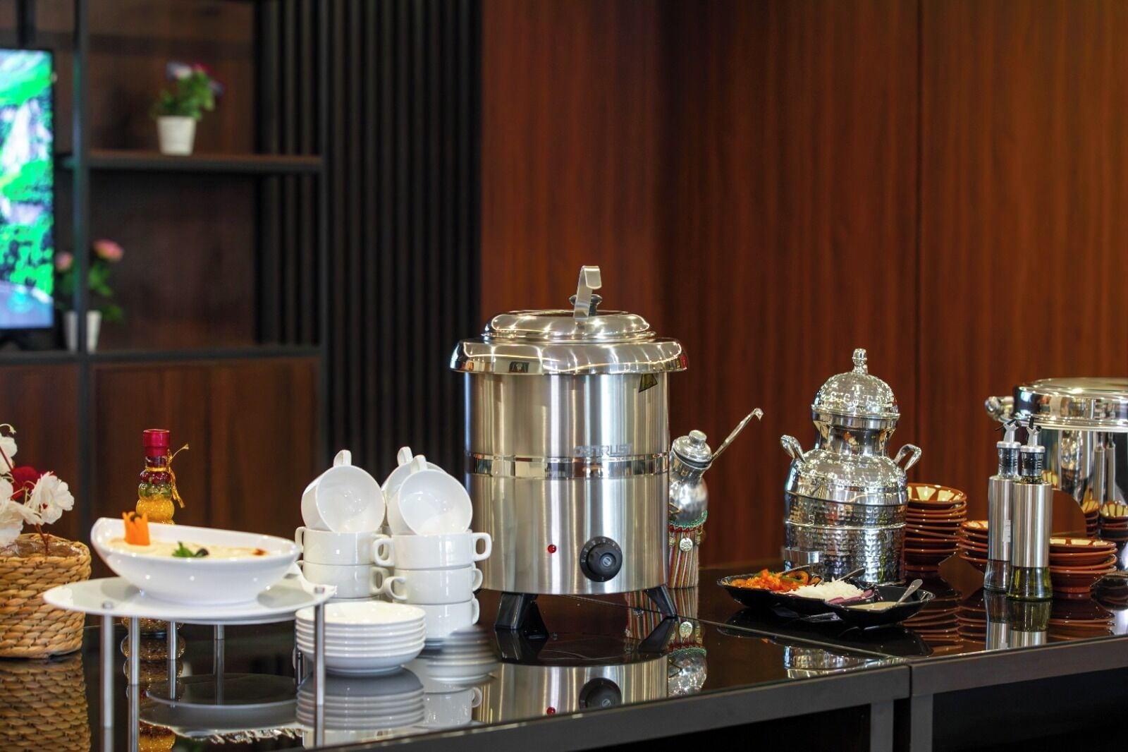Una mesa de buffet con diversos alimentos y utensilios para servir.