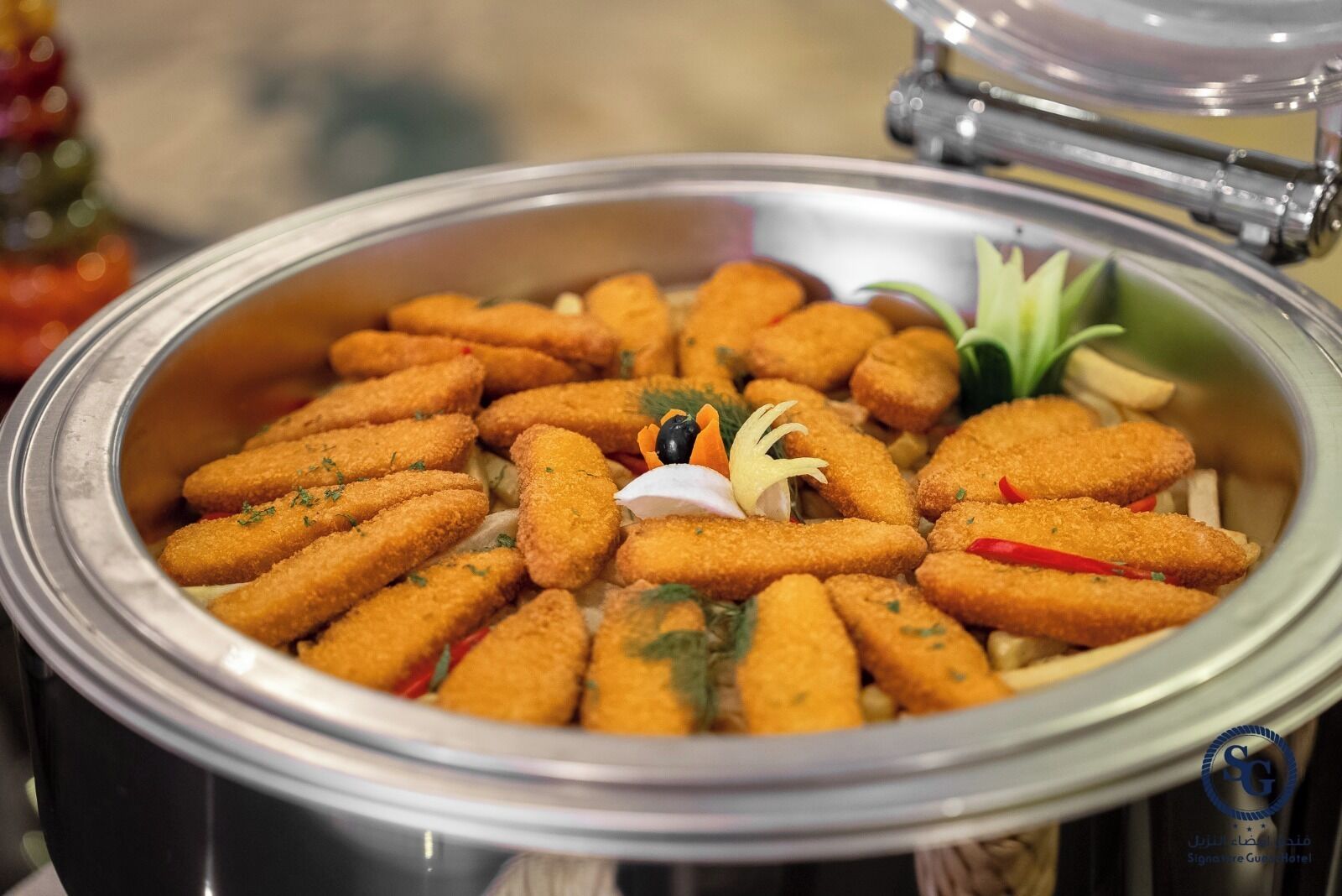 Ein Buffet mit goldbraunen, frittierten Speisen, garniert mit Kräutern und Gemüse.