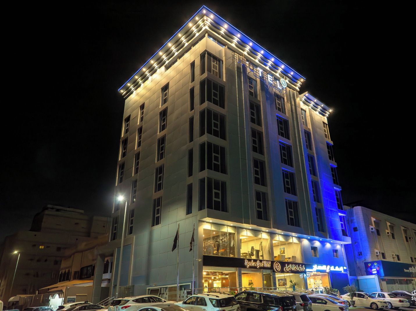 Un hotel de varios pisos con letreros iluminados y una entrada destacada.