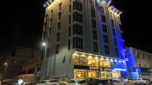 A multi-story hotel with illuminated signage and a prominent entrance. - فندق إمضاء النزيل الفندقية (Jeddah)
