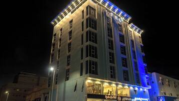 Un hotel de varios pisos con letreros iluminados y una entrada destacada.