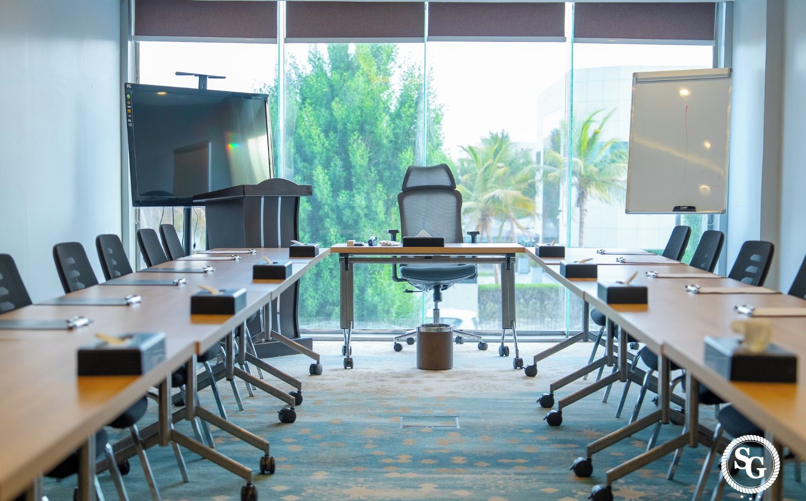A conference room with a long table, chairs, a projector, and a whiteboard.