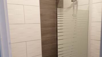 Een bad/douchecombinatie, toiletpapier