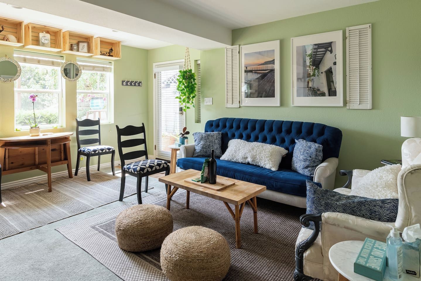 Ein Wohnzimmer mit einem blauen Sofa, zwei Sesseln, einem Holztisch und einem kleinen Beistelltisch.