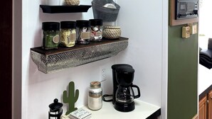 A kitchen with a coffee station, shelves with kitchenware, and a coffee maker. - Perfect Place for a Perfect Vacation (Kissimmee)