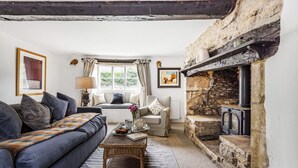 A cozy living room with a sofa, armchair, and a fireplace. - Willow Cottage, Chilmark, Wiltshire (Chilmark)