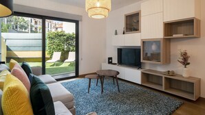 A modern living room with a sofa, TV, and shelves. - In the Funchal Centre, with outdoor area - Pena II (Funchal)