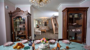 A dining area with a table set for a meal, a staircase, and a living room in the background. - house 200 m2 4 bedrooms 4 bathrooms for 10 people in the valley of the kings (Azay-sur-Cher)