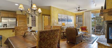 A spacious living area with a dining table, chairs, a sofa, and a fireplace.