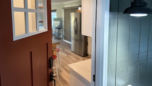 En hall med en dörr som leder in till ett köksområde.