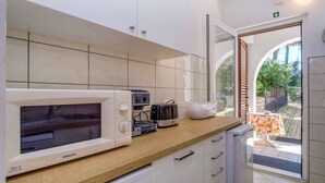 A kitchen with a microwave, toaster, and coffee maker on the counter.