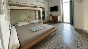 Un dormitorio con literas, un escritorio, una silla, un televisor y un mapa en la pared.