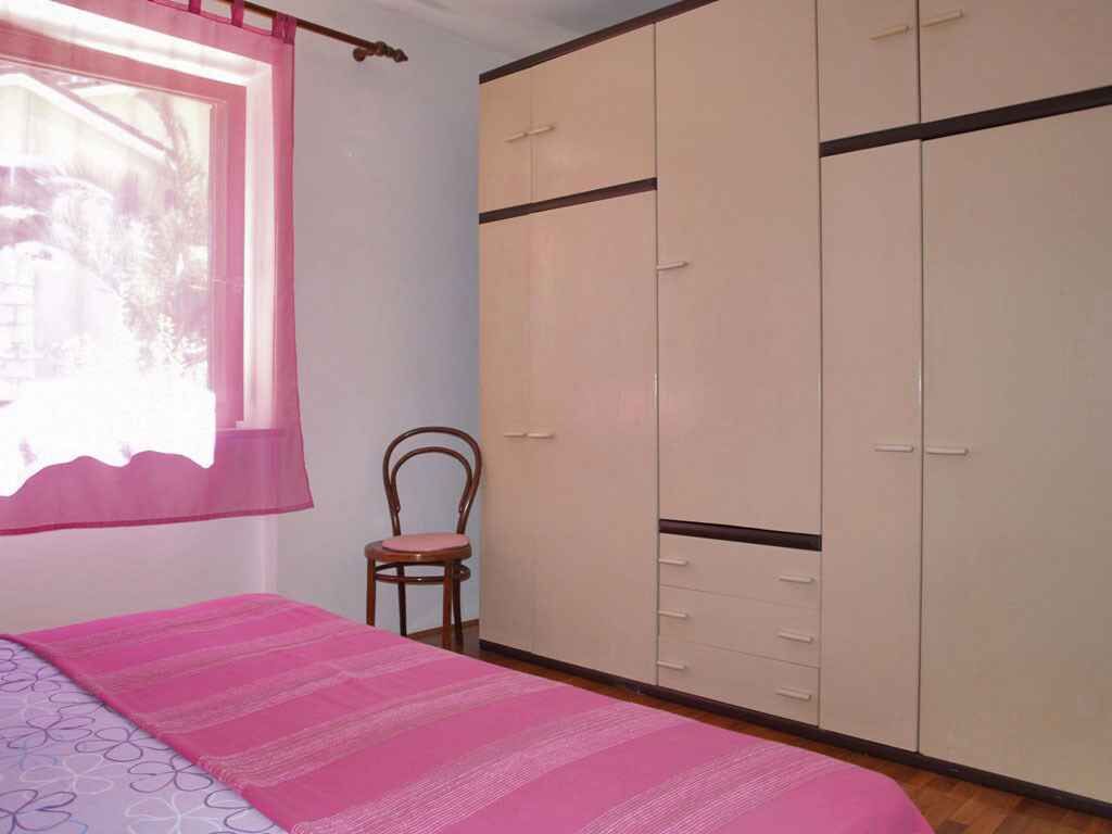 Une chambre à coucher avec un lit, une chaise et une armoire.