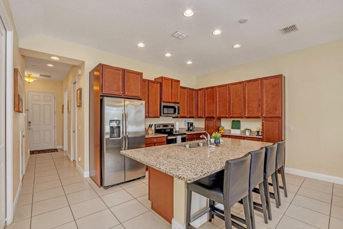 A modern kitchen with granite countertops, stainless steel appliances, and wooden cabinets.