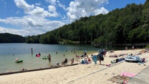 A beach with people swimming and relaxing, surrounded by a forested area. - 2 Views!  Front view of Lake Glenville & back view of Christmas Tree farm! (Glenville)