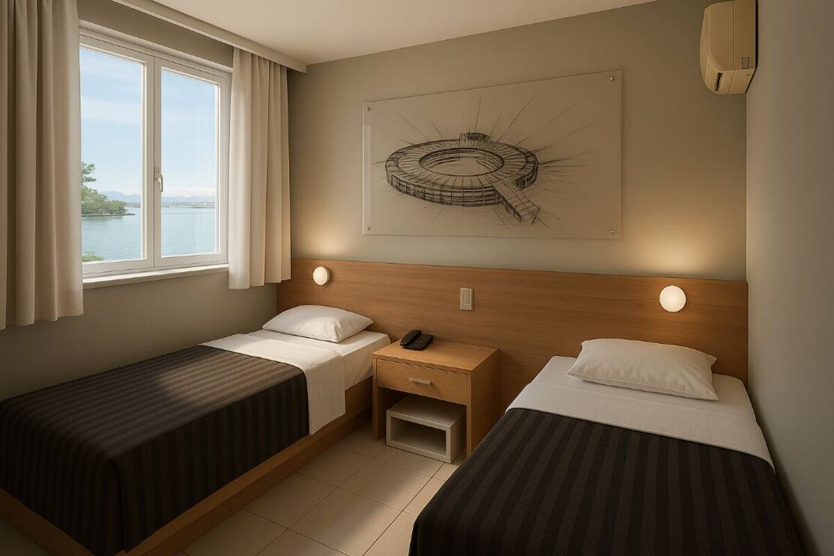 A hotel room with two beds, a window with curtains, a nightstand with a phone, and a wall-mounted air conditioner.