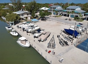 A marina with several boats docked, a covered trailer, and a small building with a blue roof.