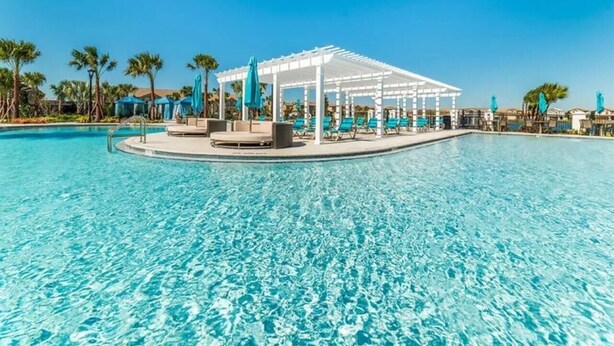 A clear blue pool with a white pergola and lounge chairs. - Luxury Villa, Clubhouse, Pool, 15 mins from Disney (Kissimmee)