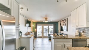 A modern kitchen with white cabinets, a stainless steel refrigerator, and a tiled backsplash.