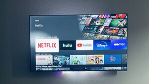Una TV a schermo piatto montata a parete, con diversi servizi di streaming.