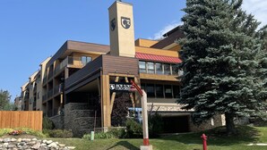 Un edificio de varios pisos con una torre destacada que exhibe un escudo.
