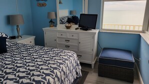 A bedroom with a bed, dresser, TV, and a view of the sea. - BEAUTIFUL DIRECT GULF FRONT CONDO FORT MYERS BEACH 903B (Fort Myers Beach)