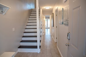 A hallway with a staircase leading to another room. - Updated Townhome Blocks from the Beach! (Panama City Beach)