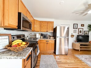 A modern kitchen with wooden cabinets, stainless steel appliances, and a granite countertop.