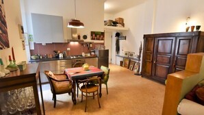 A compact living space with a dining area, kitchen, and a large cabinet.