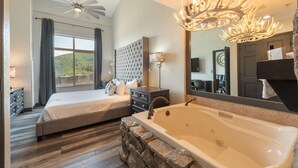 A bedroom with a large bed, a separate bed, a bathtub, and a view of the outdoors. - Westgate 1BR, private patio, multiple pools, resort amenities, tennis, onsite spa, restaurant (Park City)