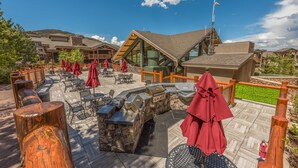 A patio area with outdoor seating, a barbecue station, and a view of the surrounding buildings. - Ski in/out at Westgate, studio, Resort amenities, Mutiple Pools, Onsite Spa and Restaurant 4802B (Park City)