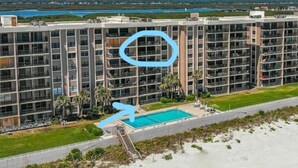 A high-rise hotel with multiple floors, a swimming pool, and a beach view. - Paradise in Ponce - Oceanfront 2BR Condo (Ponce Inlet)