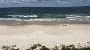 A beach with a sandy shore, waves, and a partly cloudy sky. - Paradise in Ponce - Oceanfront 2BR Condo (Ponce Inlet)
