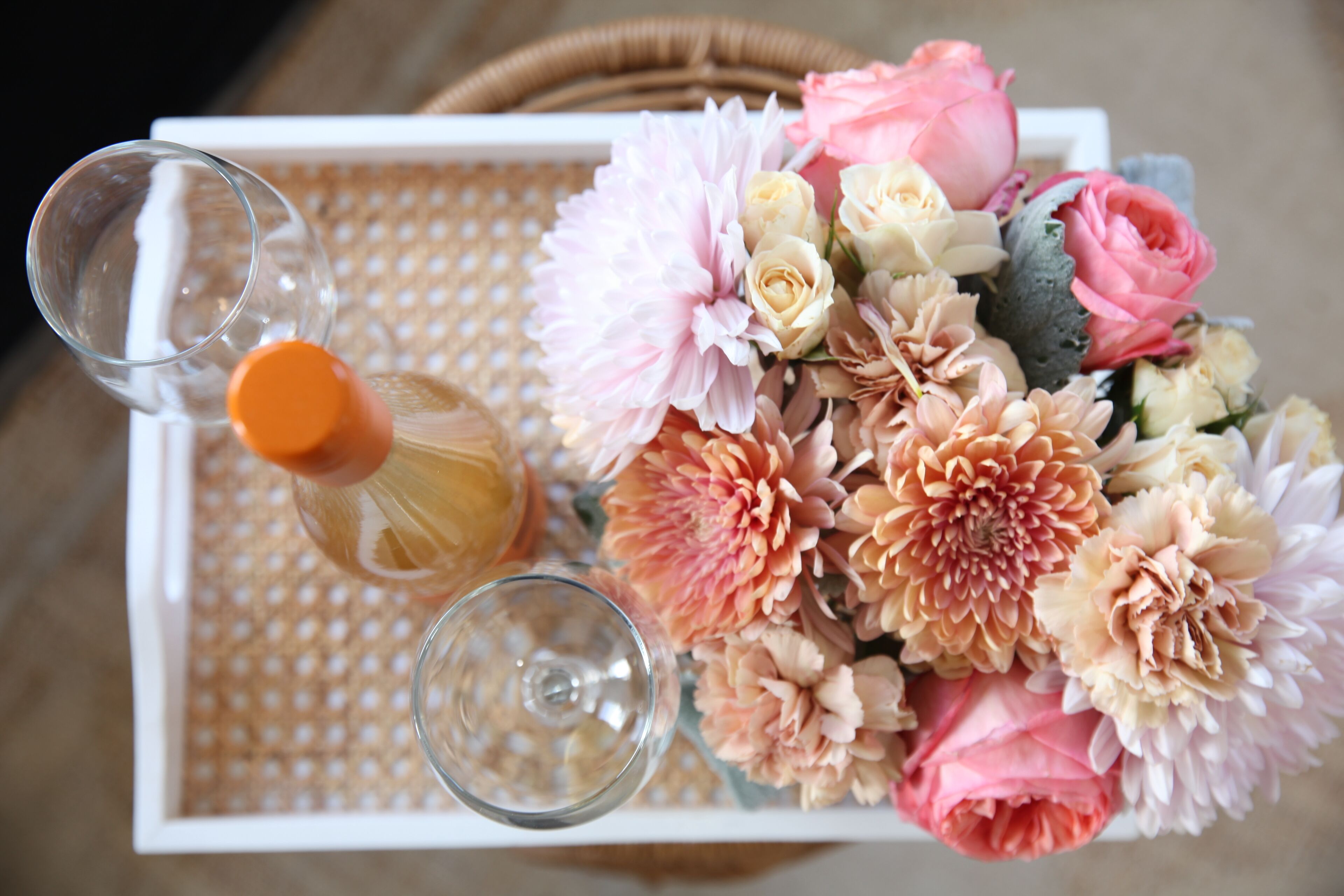 A tray with a bottle of champagne, two glasses, and a bouquet of flowers.