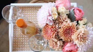 A tray with a bottle of champagne, two glasses, and a bouquet of flowers.