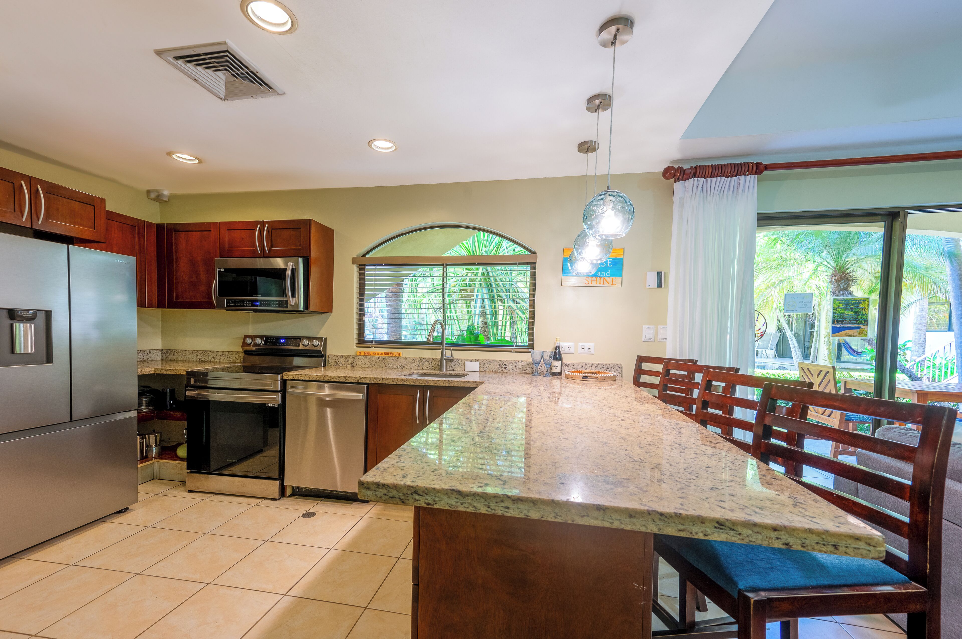 A modern kitchen with granite countertops, stainless steel appliances, and a large island with seating.