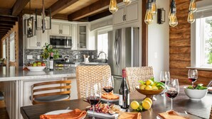 A modern kitchen with wooden beams, stainless steel appliances, and hanging light fixtures. - Chateau Syrah by AvantStay | Picturesque Estate w/ Pool, Pickleball, Hot Tub (Temecula)