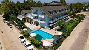 Un grand immeuble doté d’une piscine, de nombreux balcons et d’un espace de stationnement.