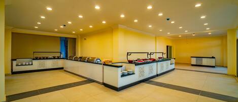 A spacious room with a long counter, multiple sinks, and overhead lighting.