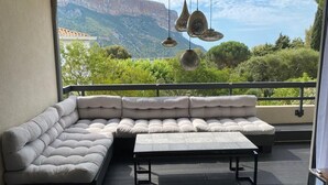 A modern outdoor seating area with a sectional sofa and a small table, overlooking a mountainous landscape. - Appartement Villa Cassis (Cassis)